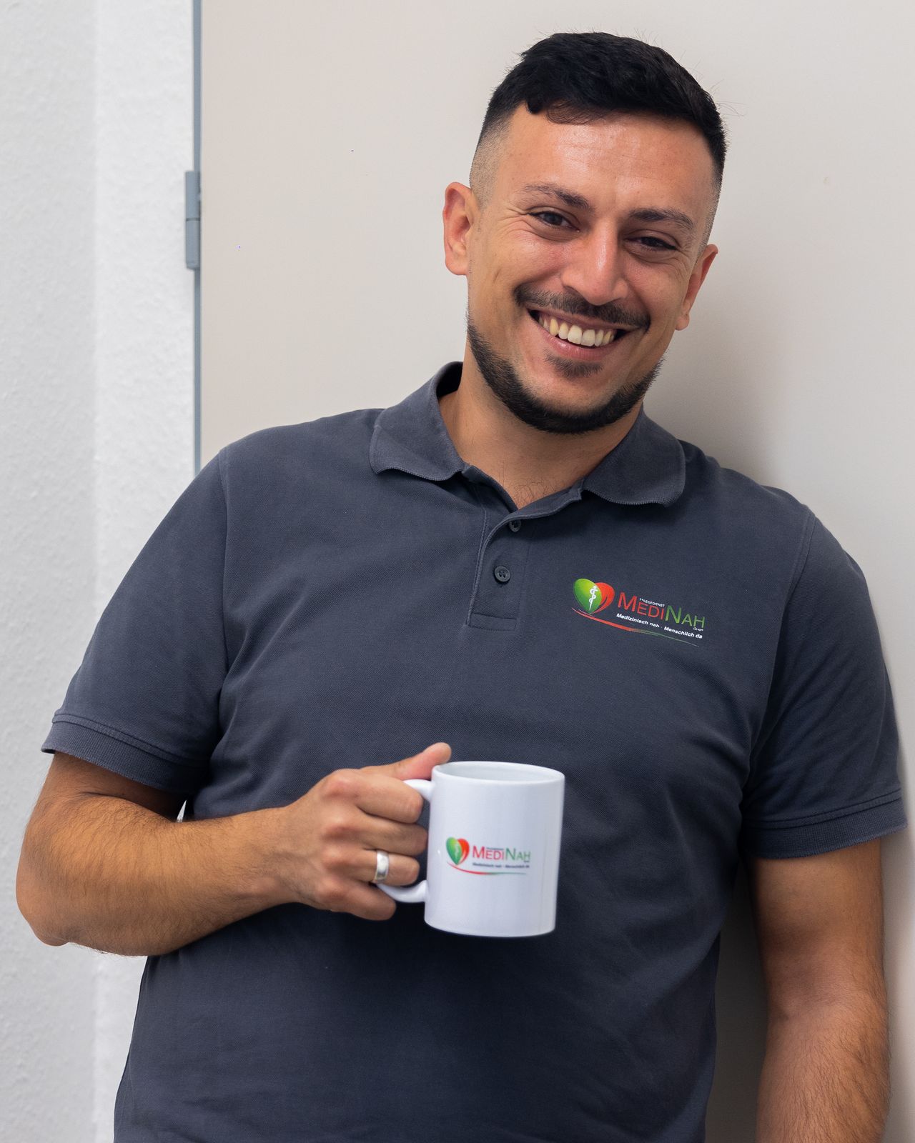 Mitarbeiter von MediNah mit Kaffeetasse, lachend